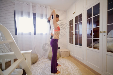 卧室女人在窗前的公寓里做瑜伽窗户活动图片