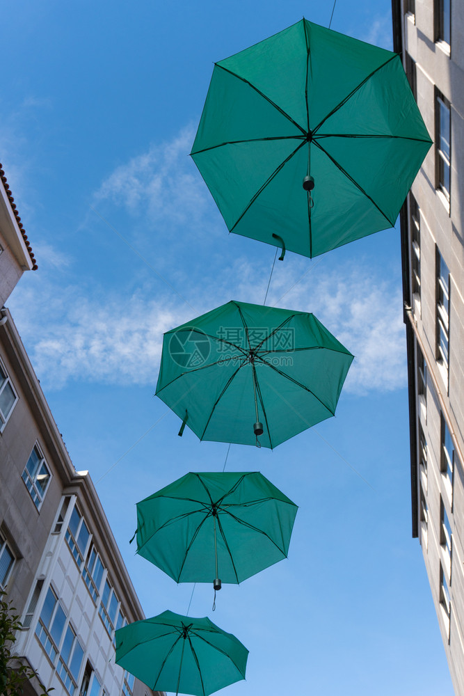 在街道上挂着绿色雨伞用于公共装饰沿着节日图片