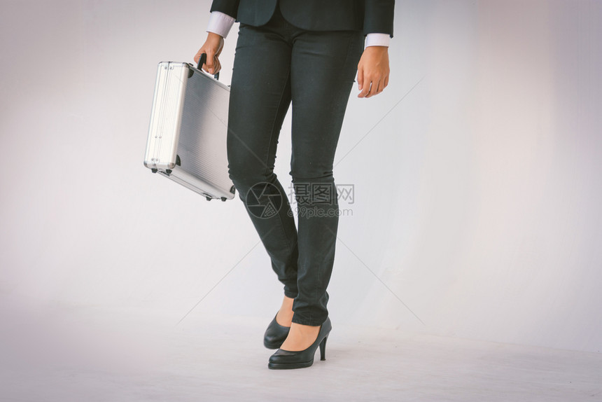 街道步行穿黑西装的聪明女人拿着公文包商业图片
