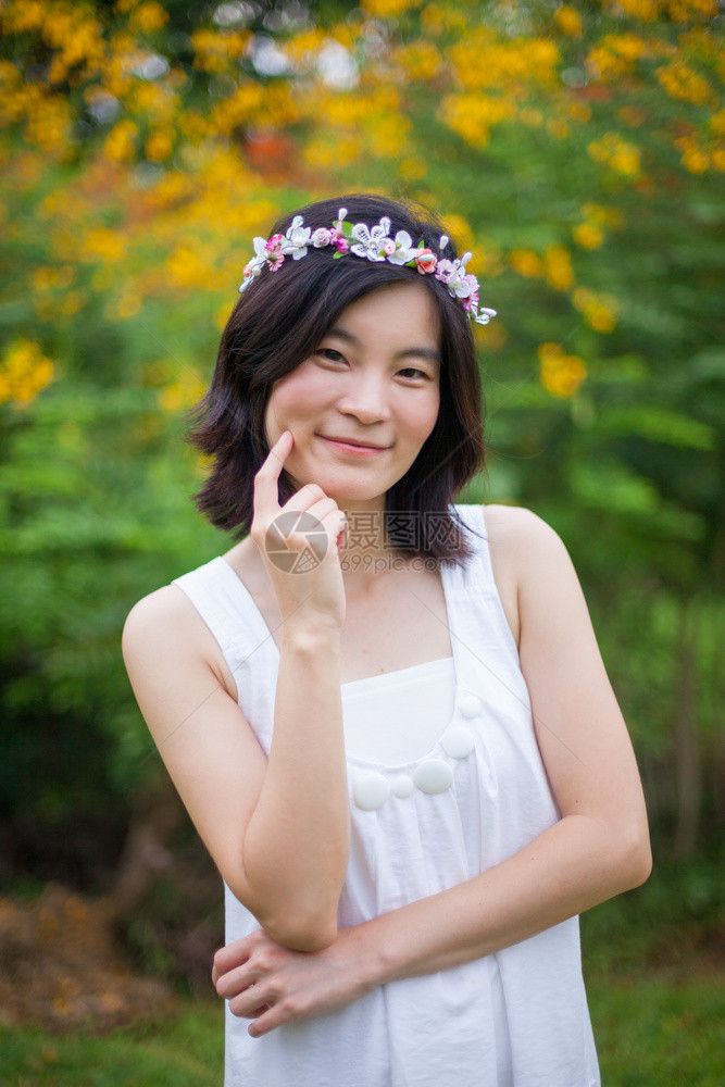 头发吸引人的美丽亚洲年轻女子带着一朵花的皇冠种图片
