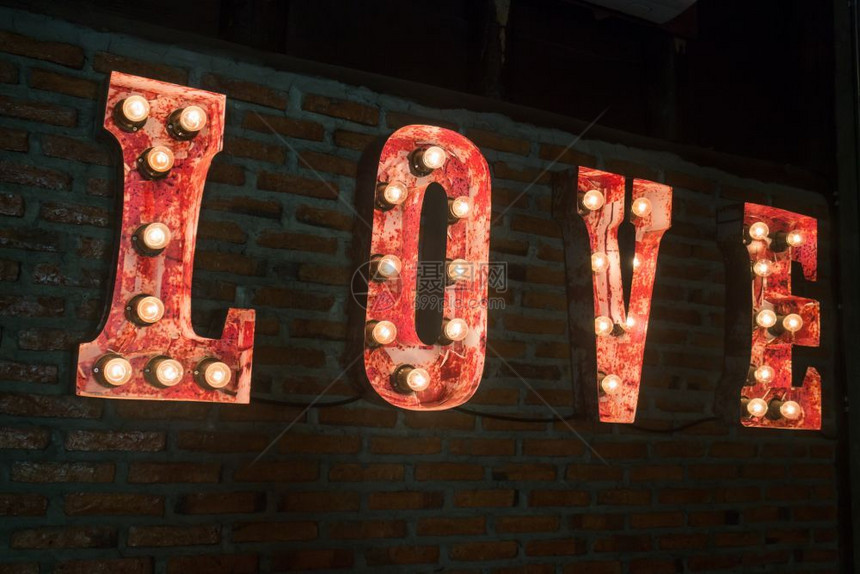 庆典情感建造在砖墙上装饰的爱情灯泡标志库存照片图片