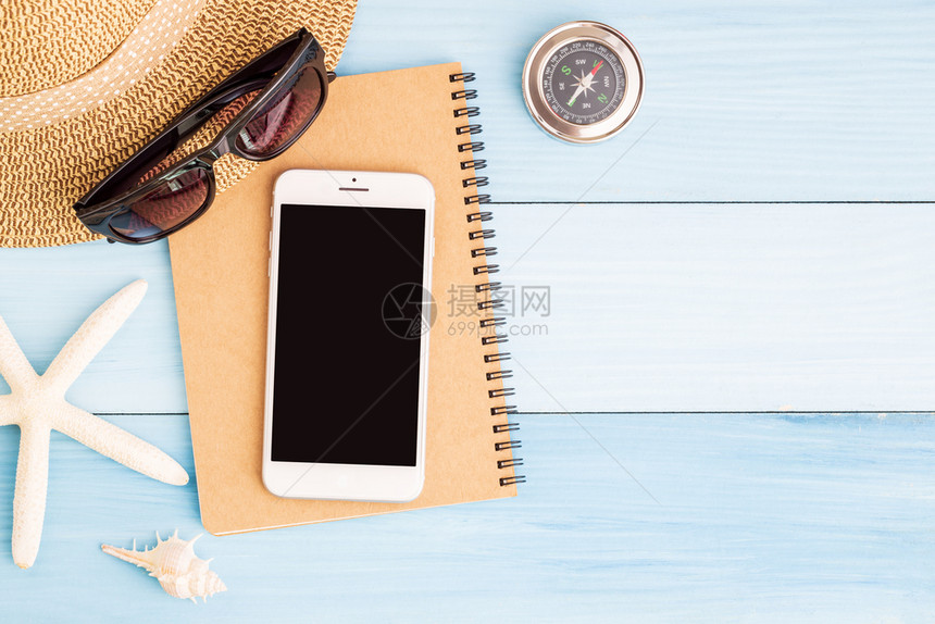 游客复制蓝木桌子上的智能手机和笔记本概念夏季旅行高架图片