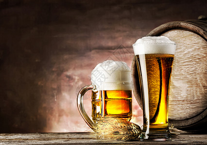 缩合穆格和一杯轻啤酒在旧的穆格桶背景上和一杯轻啤酒透明气泡图片