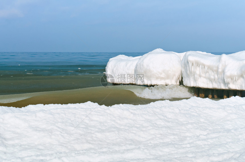 冷冻天防波堤在冰中断水雪覆盖层上图片
