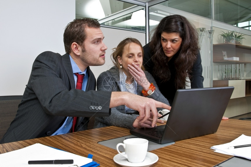 套装三名工作人员在浏览笔记本电脑时讨论财务事项同时浏览笔记本电脑初级明尼斯图片