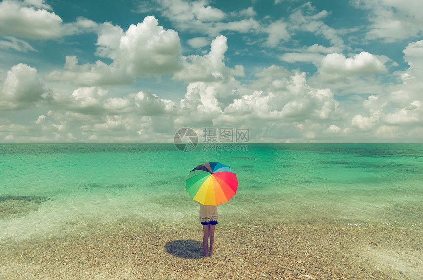 站在沙滩上的女人打太阳伞图片