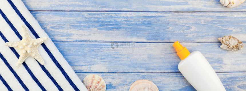 海边桌上的防晒霜与桌上的贝壳图片
