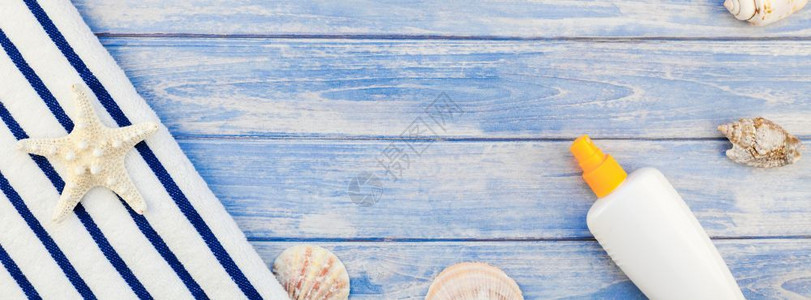 海边桌上的防晒霜与桌上的贝壳图片