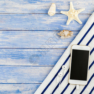 白色的小样蓝海滩毛巾智能手机海贝壳象鱼的顶端视图其背景为面糊蓝木板底并附有空间模拟文本版板SpreplaceModupBlook背景图片