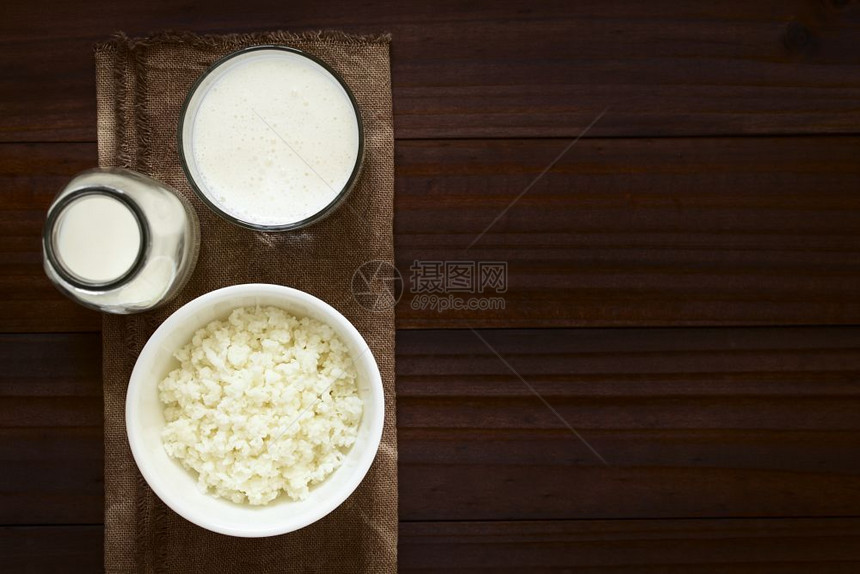 食物细菌碗里的开菲尔谷物玻璃杯中的新鲜开菲尔饮料和一瓶牛奶用自然光选择聚焦在头顶拍摄专注于开菲尔谷物和饮料图片