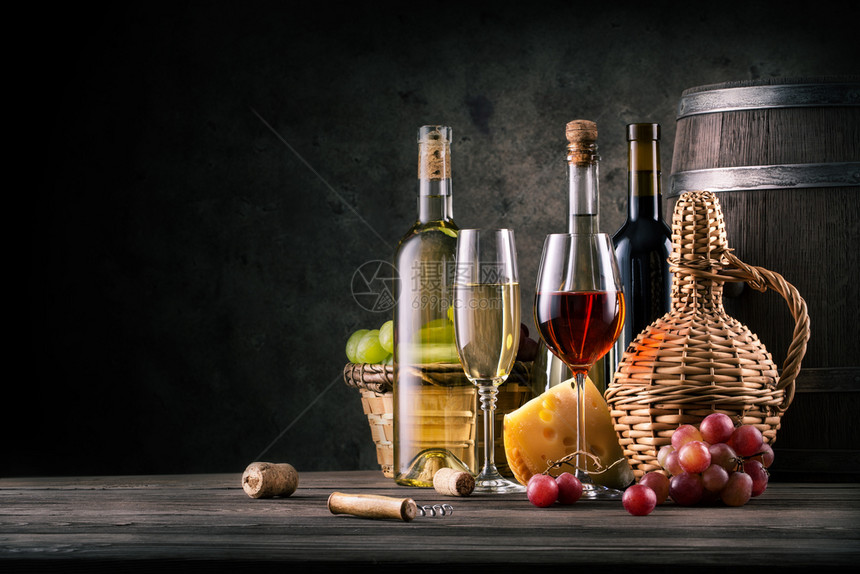 仍然以木制餐桌上的红酒为主题背着黑暗景的木制餐桌仍以上的红酒为主题工作室红酒杯色的图片