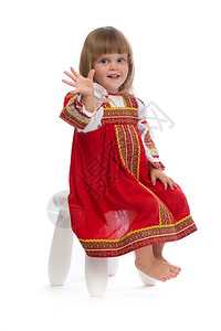 穿着红色传统礼服的小女孩坐在椅子上孤立白色时尚健康室内图片