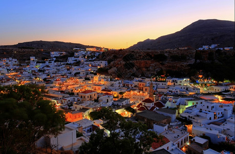 建筑学看着黄昏时的林多斯村屋顶海岸希腊语图片