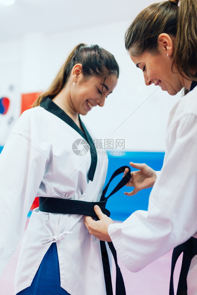 两个年轻女人穿衣服着泰拳道西装他们的担武术图片