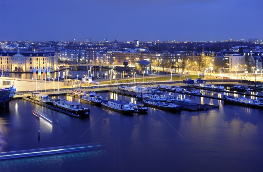 船黄昏运动夜晚阿姆斯特丹港口交通横越街道灯光照亮了各种历史建筑AhmadanHattash图片