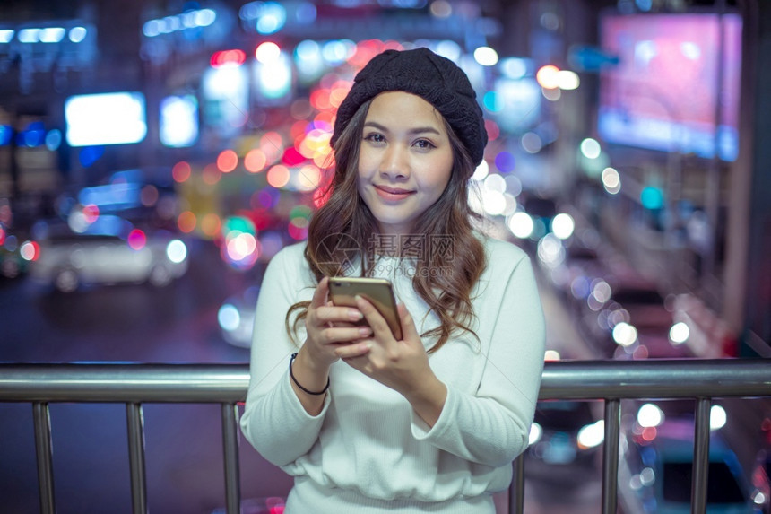 商业屏幕美丽的年轻亚洲女在夜间使用手机的户外肖像画女青年发短信图片