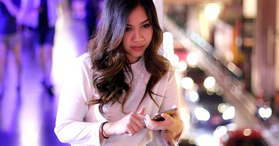 街道年轻的美丽亚洲女在夜间使用手机的户外肖像画女青年电话图片
