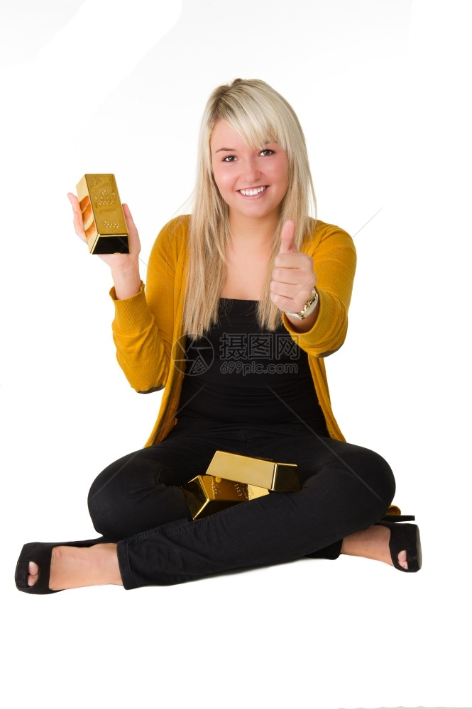 白色的微笑年轻快乐女孩金条坐在地板上举起大拇指在白背景之上商业图片