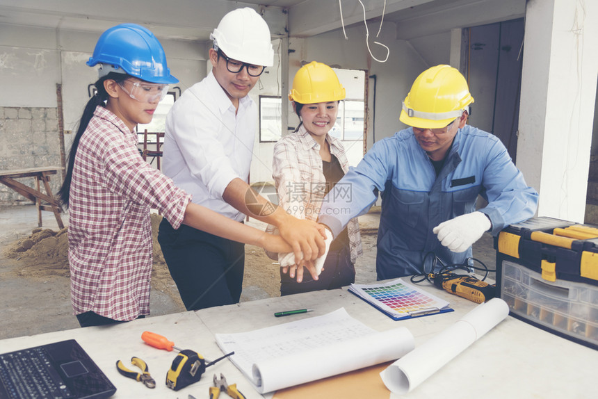 与建筑工地的程师和头握手进行建设工作团队合头盔领班人们图片