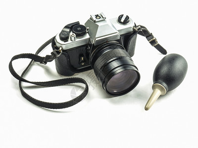 复古的金属旧式单一镜头反射相机用橡胶吹泡泵清洁器隔着白色背景时尚图片