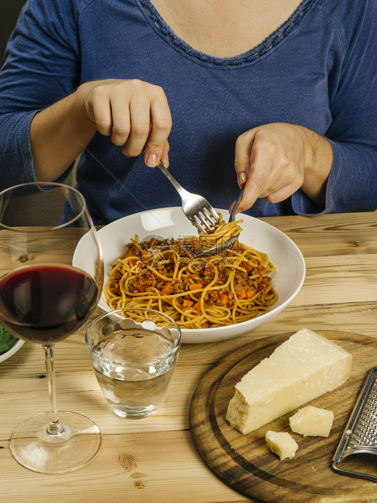 美食自制照片上一位女在生餐桌边喝着一杯红酒吃碗传统意大利面汤叉图片