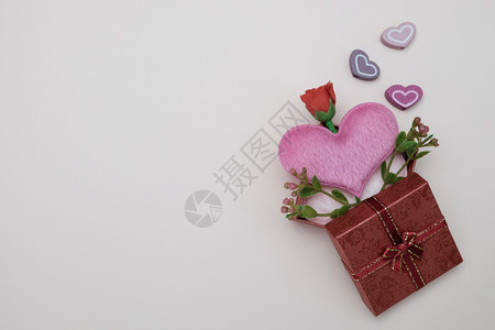 小型的盒子螺柱心形枕头和以粉红背景情人节概念为礼物盒中的小花图片