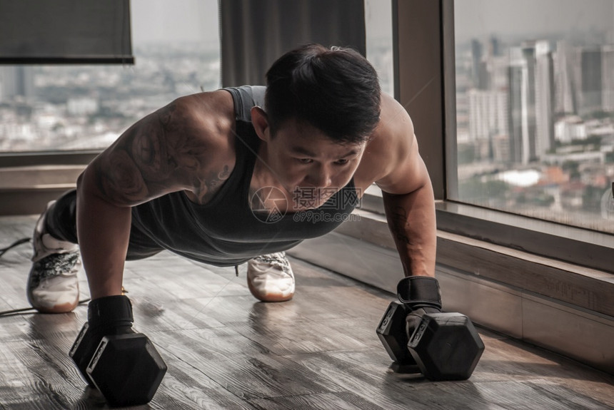 活动合身泰国曼谷2019年月6日健身俱乐部或在哑铃上做俯卧撑的英俊肌肉男健康生活方式建体运动员健壮肌肉或者图片