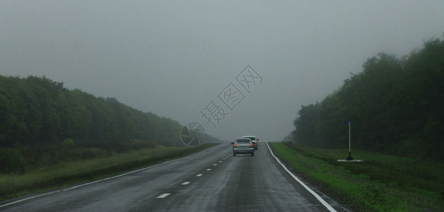 自动禁令公路风景白天通过迷雾路行驶汽车白种人宽的草地背景