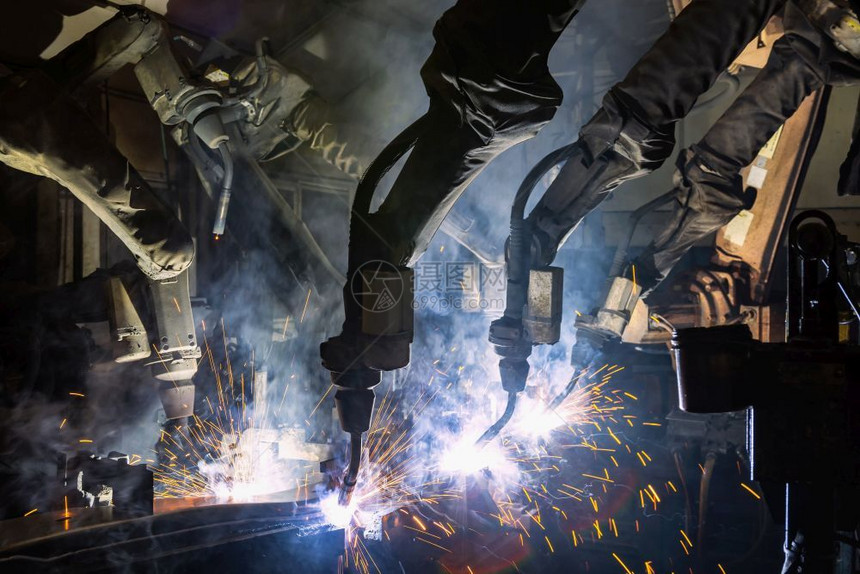 工业焊接机器人正在生产线上焊接现代的闪发光焊机图片