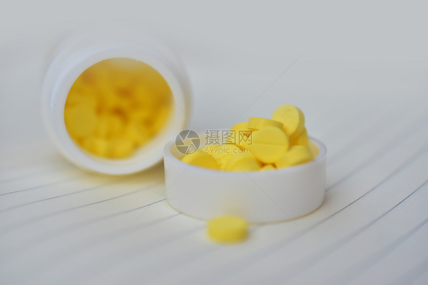 桌上摆放的黄色药片图片