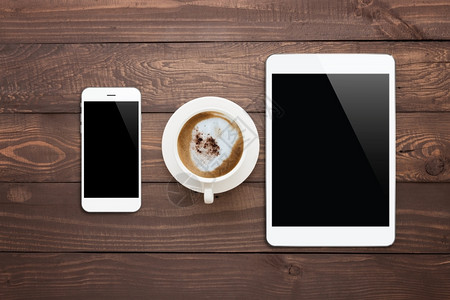 最佳白色电话平板和咖啡杯在木材桌顶视图应用空气图片