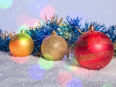 雪地上的圣诞装饰品飘落的雪花和散景明亮的圣诞节卡片图片