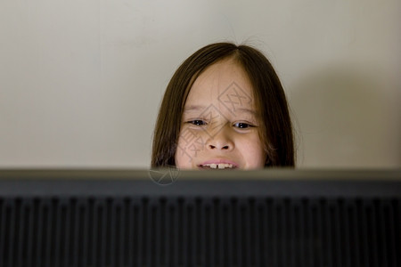 人房间监视器年轻女孩笑着看计算机屏幕的年轻女孩图片