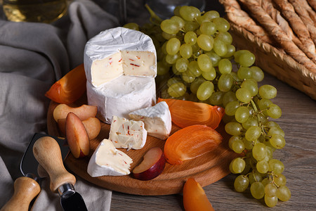 桌子好吃午餐芝士乳酪和白葡萄切片半西门和李子是红酒的大开胃菜图片
