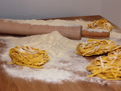 别针食用在木桌上配有滚卷平和面粉的意大利食营养图片