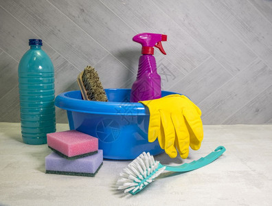 家庭主妇带有清洁工具的蓝色洗碗盘和作为脱脂剂的洗涤和带抹布的刷子清洁工具的洗碗盘白色背景
