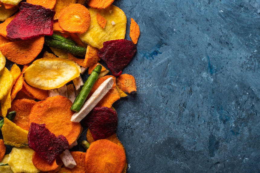 香气豌豆调味料来自胡萝卜甜菜和其他蓝背景蔬菜的干枯薯片有机饮食和素品图片