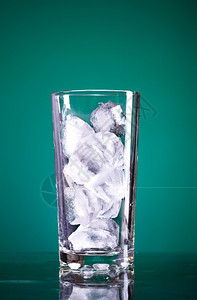 绿色背景上满是冰的玻璃杯白色清爽鸡尾酒图片