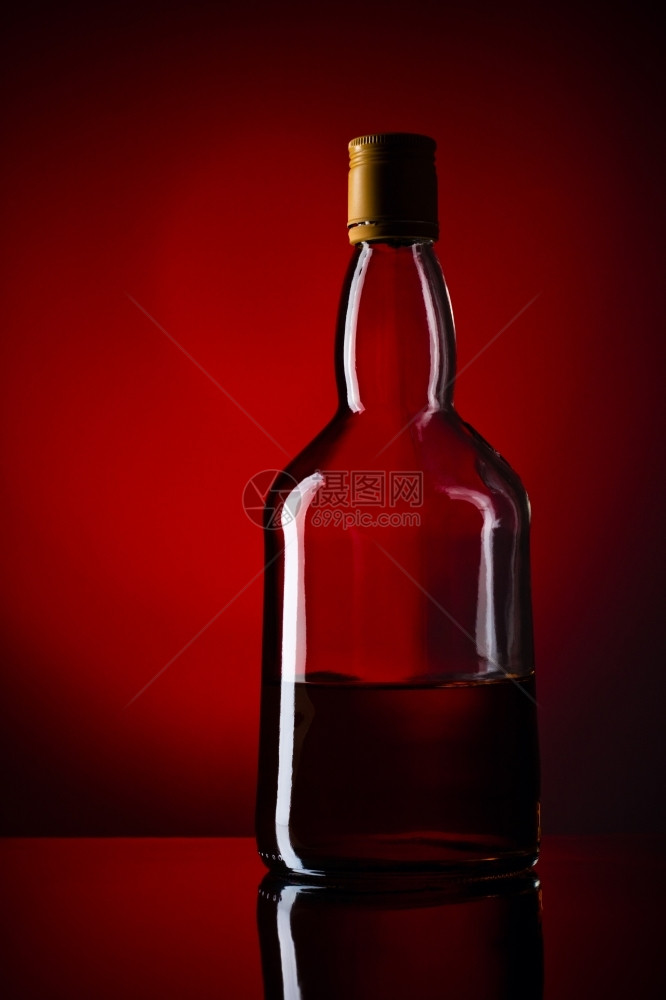 威士忌瓶红色背景科涅克白兰地苏格人桌子图片