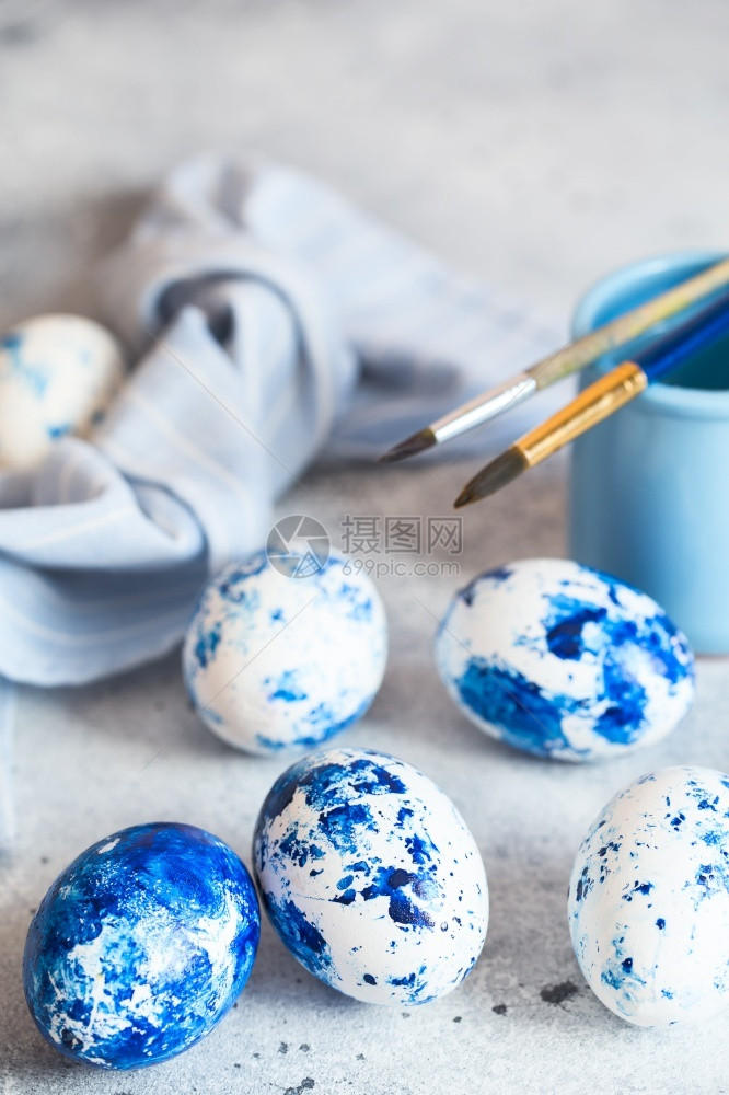 灰色背景的蓝斑点东方鸡蛋配有油漆和刷子装饰鸡蛋为复活节做准备为复活节有斑点的丰富多彩原来图片