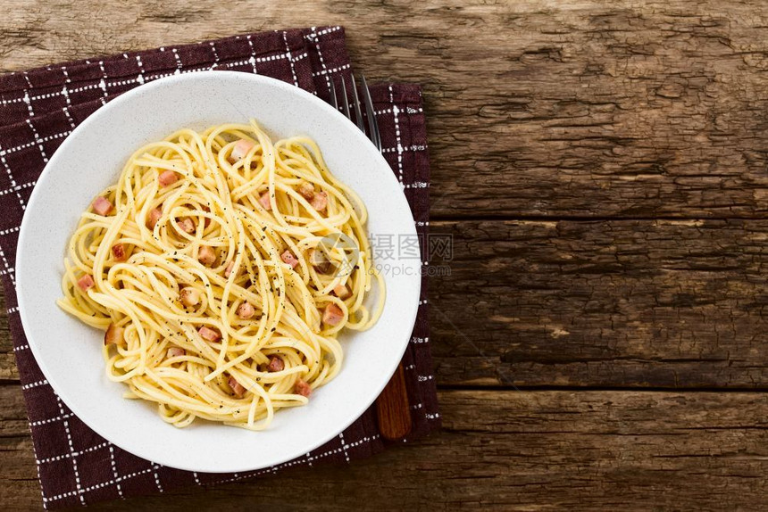 帕尔马干酪熏肉意大利传统的面粉加碳马拉SpaghettiCarbonara在盘子上服役拍摄了生锈木材的顶部照片侧面有复制图片