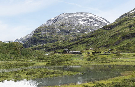 挪威夏季约斯特达尔布林山上下雪自然房区高清图片