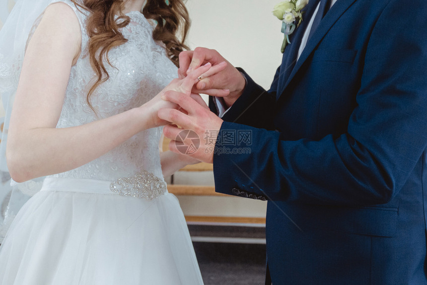 新郎把结婚戒指戴在新娘手上图片