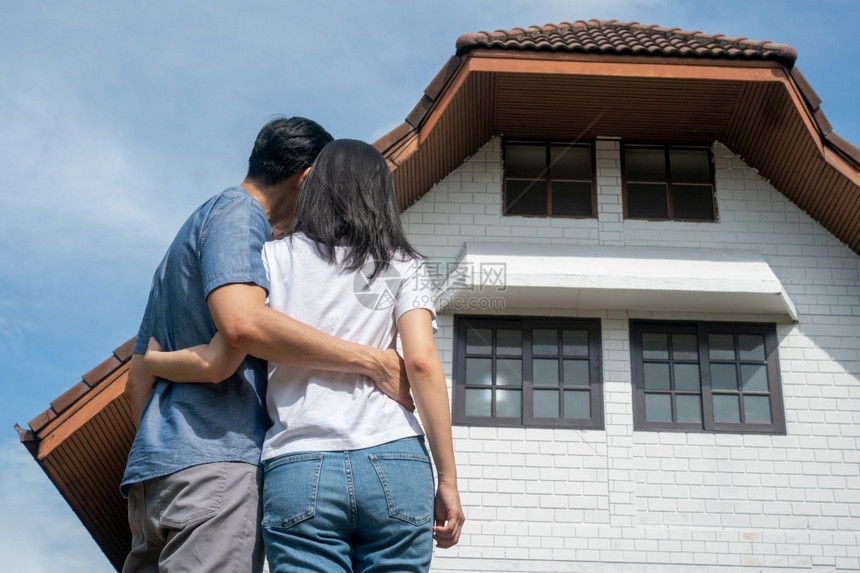 成就快乐的一对夫妇在新家前白天搬并开始一个新的家庭生活概念拥有房主和搬迁户外正面图片