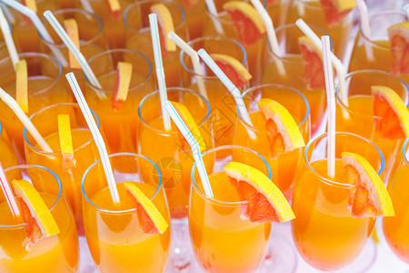 红橙汁鸡尾酒用长笛杯和新鲜橙子切片画在白桌闭着的图片上液体夏天一种图片