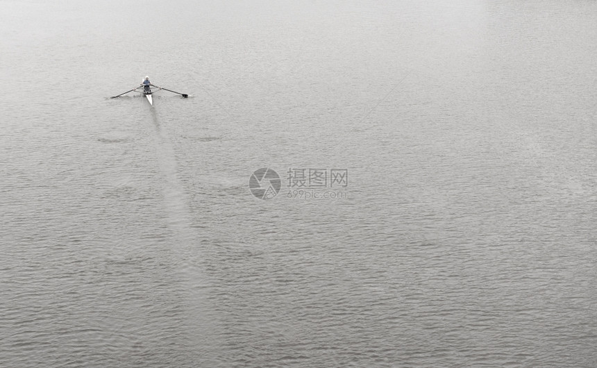 在冷水表面的平静上划船单人运动独行滑雪努力河强的图片