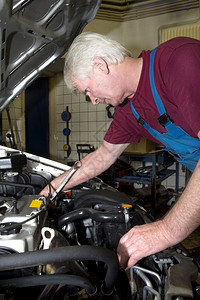 修理一名高级汽车机修工在库内维修一辆汽车纹身工具图片