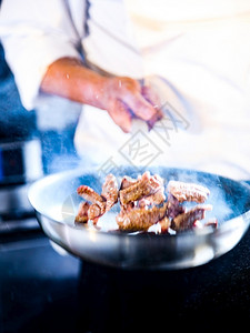 厨师在房烹饪食物师准备在炒锅中煎炸食物热的搅拌酒店图片