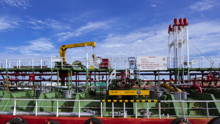 在造船厂对白云和蓝天空背景进行维护时在原油轮上安装起重机的管道系统阀门燃料泰国图片