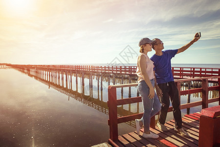 活动假期在红木桥上拍摄照片对抗太阳升起的天际时夏图片